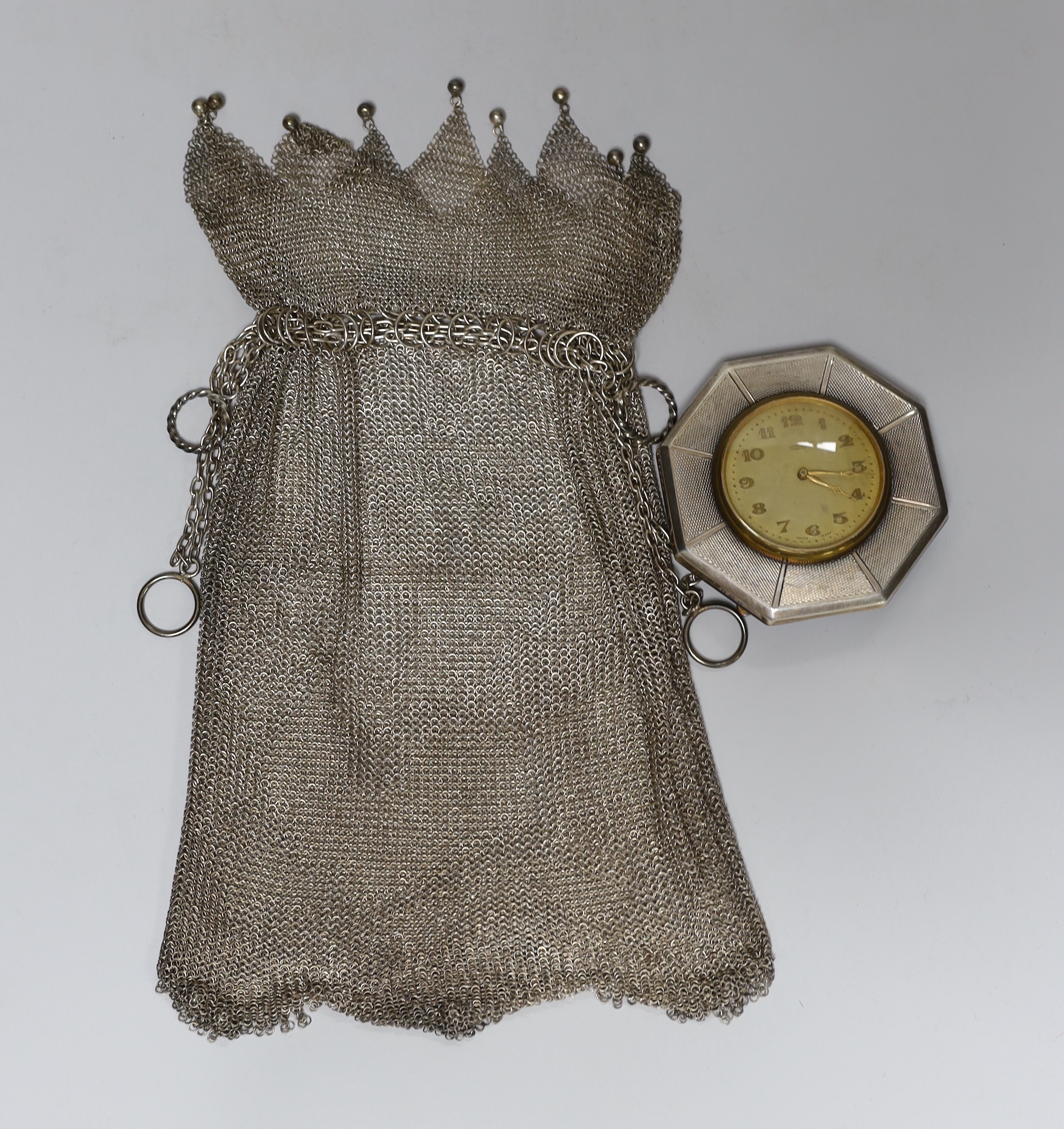 A George V silver mesh evening bag, 10.9oz and a silver mounted 8-day timepiece.